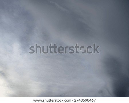 A dramatic sky with dark storm clouds gathering and lighter wispy clouds in contrast.