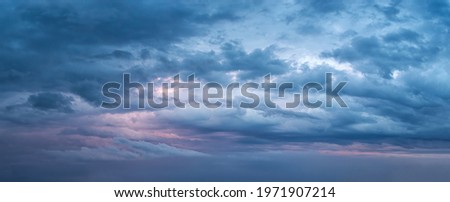 Dramatic sky at evening panoramic shot. Scenic blue gray clouds before the storm. Overcast cloudscape before the rain. Blue hour stormy cloudscape. Dark thunderstorm sky wide image. Sky only.
