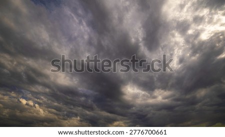 Dramatic sky filled with dark, heavy clouds. Ultra-wide angle view.