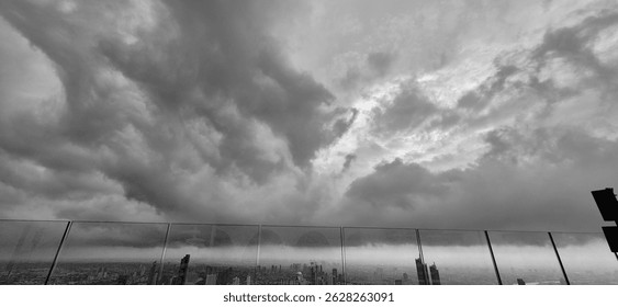 A dramatic sky filled with dark storm clouds looming over the city skyline. The urban landscape contrasts against the moody and atmospheric sky, perfect for editorial use focusing on weather change or
