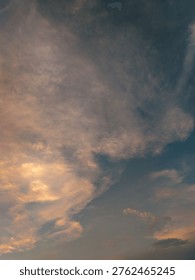 Dramatic sky filled with textured clouds during sunset, blending warm and cool tones for a stunning background.