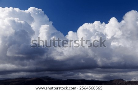 Dramatic sky with large cumulus clouds and dark blue sky over them
