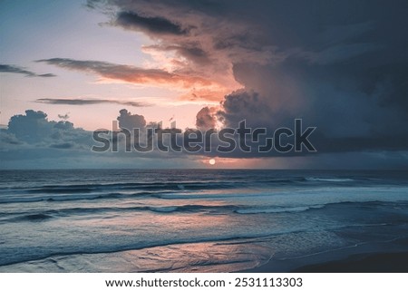 Dramatic sky with low sun behind clouds above the ocean