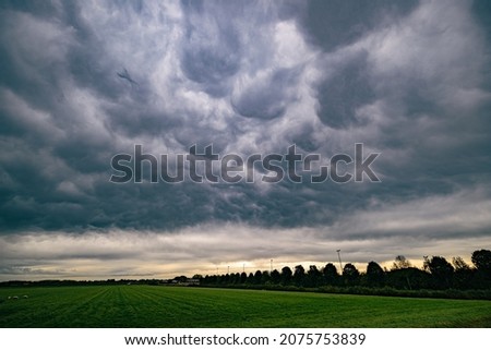 Dramatic sky with mammatus or bubble clouds at the leading edge of a cold front over the western part of Holland