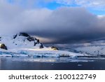 Dramatic sky over the coastal glaciers and icebergs of the Antarctic Peninsula landscape