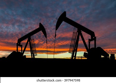 Dramatic Sky Over Two Pumpjacks In Rural Alberta, Canada. These Jacks Can Extract Between 5 To 40 Liters Of Crude Oil And Water Emulsion At Each Stroke.