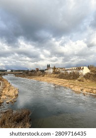 Dramatic sky over the Warta river in Poznań, Poland. Autumn colors frame the historic buildings.