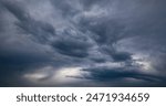 Dramatic sky panorama just before a heavy thunderstorm with lightning and thunder in spring. Contrasting cloud formations in rainy weather in Germany. Natural background in shades of blue and grey.