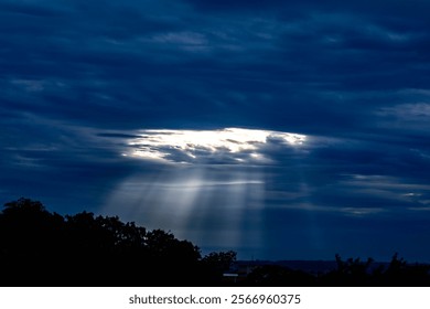 Dramatic sky with rays of light coming out of the clouds