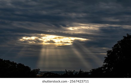 Dramatic sky with rays of light coming out of the clouds