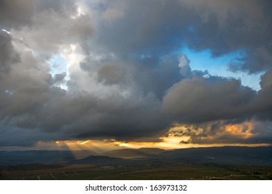 Dramatic sky and the rays of the sun above the valley