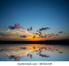 dramatic sky reflected in the water at sunset