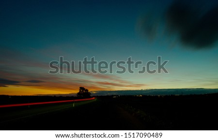 Dramatic sky with road and car tail lights