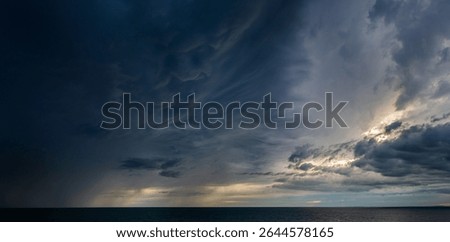 Dramatic sky with storm clouds before rain. Panoramic view of the stormy sky and sea.  Concept on the theme of weather, natural disasters.
