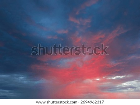 Dramatic sky with storm clouds illuminated by red sunset or sunrise. Vivid colorful cloudscape for nature banner or weather background. Bright sunset or sunrise light. Overcast weather.