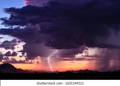 Dramatic sky with storm clouds and lightning bolt at sunset