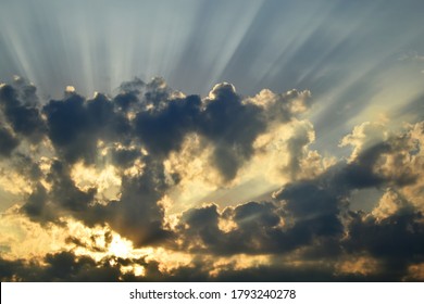 Dramatic Sky With Stormy Clouds, The Bright Yellow Sun Breaking Through The Dark Stormy Clouds 