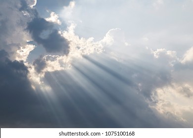 Dramatic Sky and Sun Rays Background. Sunbeams Light and Moody Cloudscape. Toned and Filtered Photo with Copy Space