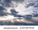 Dramatic Sky With Sun Rays Breaking Through Clouds Over a Quiet Horizon at Dusk