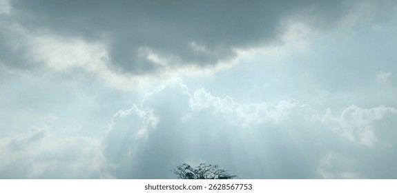 Dramatic sky with sun rays piercing through clouds, creating a heavenly, serene atmosphere. Perfect for nature, spirituality, and weather-related themes