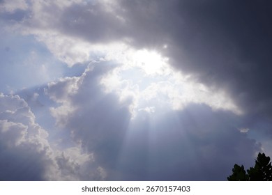 Dramatic sky with sunlight shining through thick clouds on a bright day