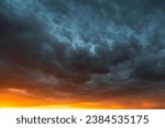 Dramatic sky at sunset, dangerous heavy gray orange color clouds in sky, abstract sky and nature background