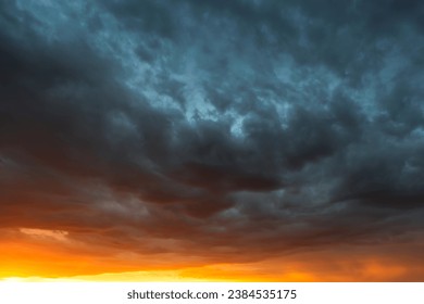 Dramatic sky at sunset, dangerous heavy gray orange color clouds in sky, abstract sky and nature background - Powered by Shutterstock