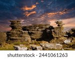 Dramatic sky at sunset over rugged rock formations in a serene landscape at Brimham Rocks, in North Yorkshire