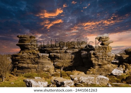 Dramatic sky at sunset over rugged rock formations in a serene landscape at Brimham Rocks, in North Yorkshire
