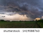 Dramatic sky as threatening storm clouds move fast over the landscape of Flanders, Belgium. A raindrop has fallen on the surface of the lens.