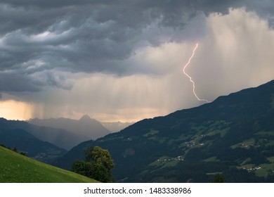Dramatic sky with thunderstorm and lightning bolt in the mountains at sunset
