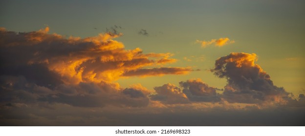 dramatic skyscape at sunset with big orange and purple cloud formation. Long horizonal crop with copy space - Shutterstock ID 2169698323