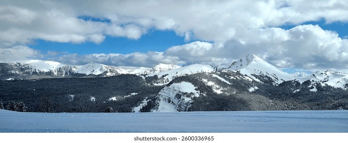 Dramatic snow-capped mountains of the Gallatin Range in winter.