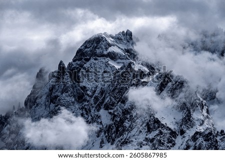 Dramatic Snow-Covered Mountain Peaks Emerging Through Clouds