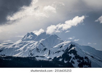 Dramatic snowy peaks emerging from storm clouds - Powered by Shutterstock