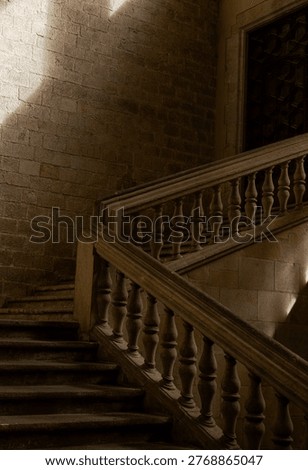 Dramatic stone staircase with sunlight and shadows inside a historic building