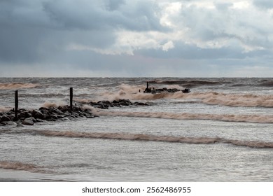 dramatic storm in the Baltic Sea, large waves crashing against the stone pier, blurred, unclear contours, rocky shore of Vidzeme, Thuja, Latvia