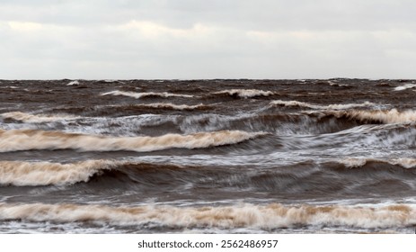 dramatic storm in the Baltic Sea, large waves crashing against the shore, blurred, unclear contours, rocky shore of Vidzeme, Thuja, Latvia