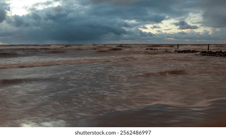 dramatic storm in the Baltic Sea, large waves crashing against the shore, blurred, unclear contours, rocky shore of Vidzeme, Thuja, Latvia