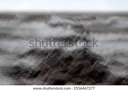 dramatic storm in the Baltic Sea, large waves crashing against the stone pier, blurred, unclear contours, rocky shore of Vidzeme, Thuja, Latvia