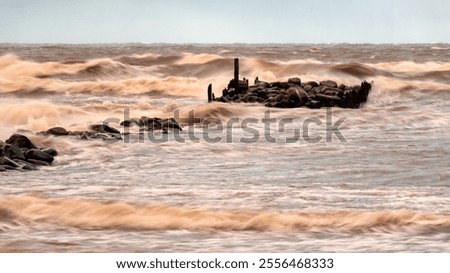 dramatic storm in the Baltic Sea, large waves crashing against the stone pier, blurred, unclear contours, rocky shore of Vidzeme, Thuja, Latvia