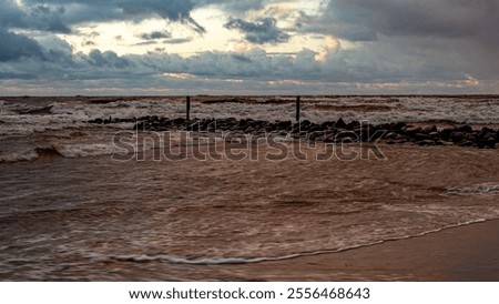 dramatic storm in the Baltic Sea, large waves crashing against the stone pier, blurred, unclear contours, rocky shore of Vidzeme, Thuja, Latvia