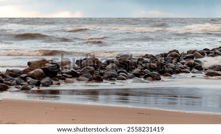 dramatic storm in the Baltic Sea, large waves crashing against the stone pier, blurred, unclear contours, rocky shore of Vidzeme, Thuja, Latvia