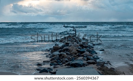 dramatic storm in the Baltic Sea, large waves crashing against the stone pier, blurred, unclear contours, rocky shore of Vidzeme, Thuja, Latvia
