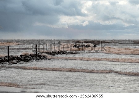 dramatic storm in the Baltic Sea, large waves crashing against the stone pier, blurred, unclear contours, rocky shore of Vidzeme, Thuja, Latvia