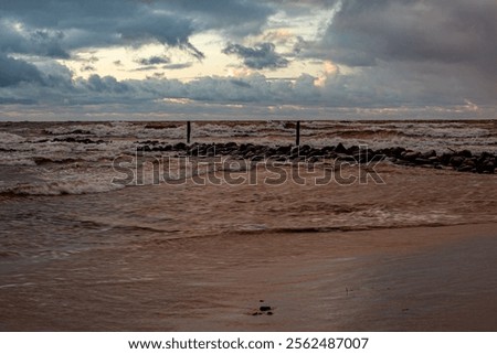 dramatic storm in the Baltic Sea, large waves crashing against the stone pier, blurred, unclear contours, rocky shore of Vidzeme, Thuja, Latvia