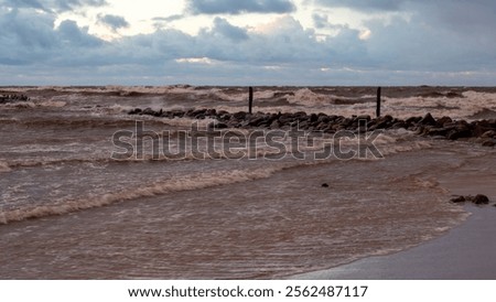 dramatic storm in the Baltic Sea, large waves crashing against the stone pier, blurred, unclear contours, rocky shore of Vidzeme, Thuja, Latvia