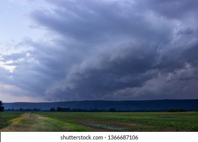 Dramatic Storm Cloud Over an Open Field with mountains in the background.