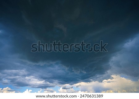 Dramatic storm clouds in blue sky associated with storm, dark, moody weather and looming atmosphere