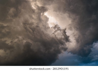 Dramatic storm clouds with a bright opening of light in the center, concept of hope, silver lining and breakthrough.